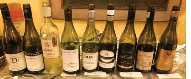 Line -up of Sauvignon Blanc bottles,resting up on their sleeves .